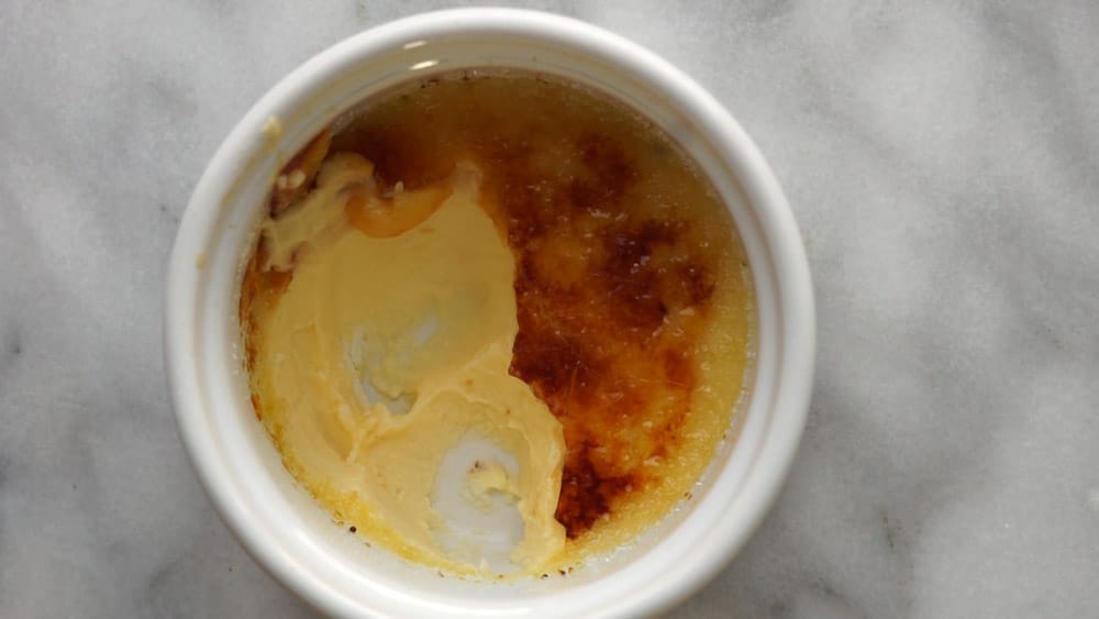 creme brulee con algunas cucharadas sacadas